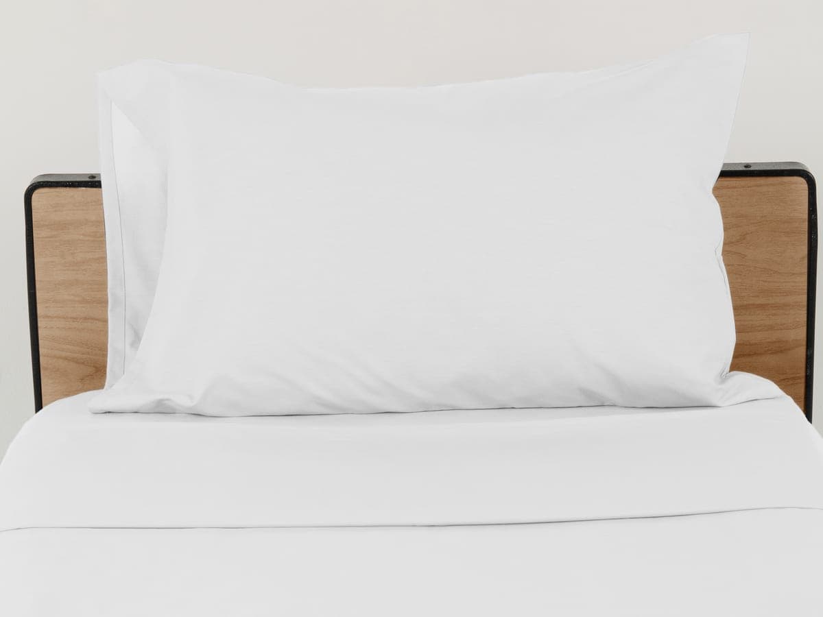 Almohada con funda blanca sobre una cama hospitalaria