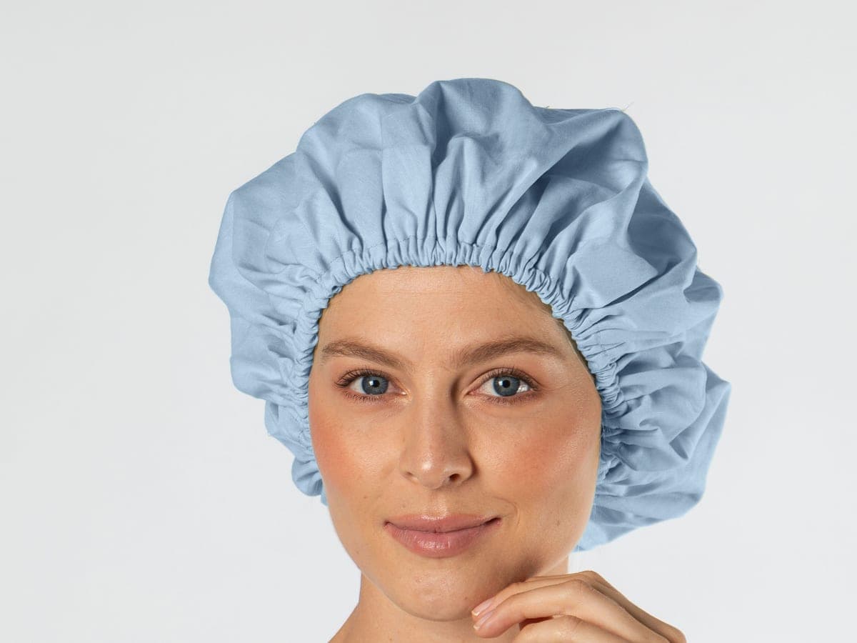 Mujer con gorro de paciente azul claro, con elástico en el borde