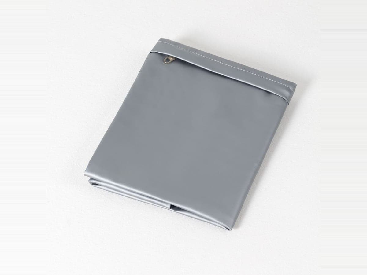 Protector de almohada gris doblado, con su cierre