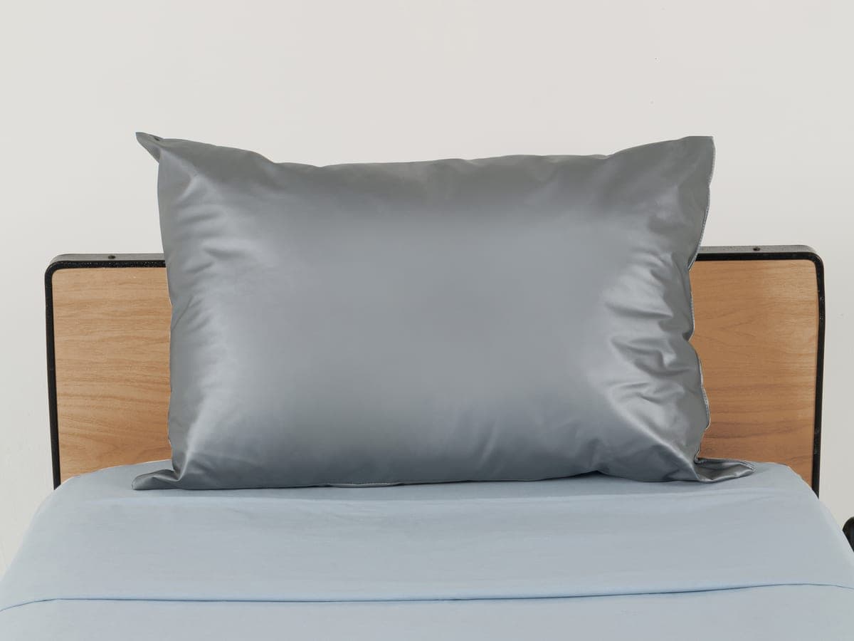 Almohada impermeable gris sobre una cama hospitalaria